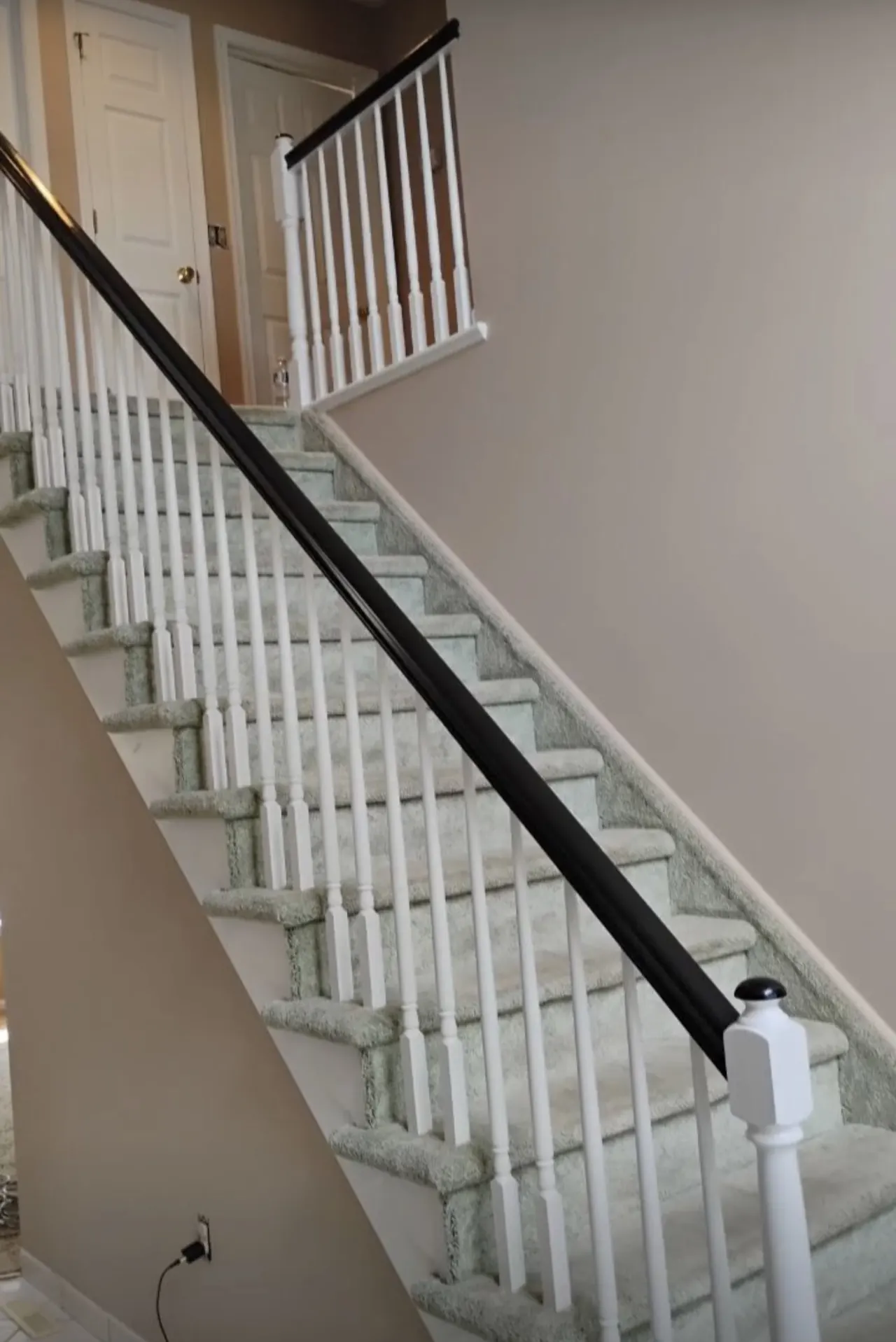 Stairway with white spindles and a dark railing